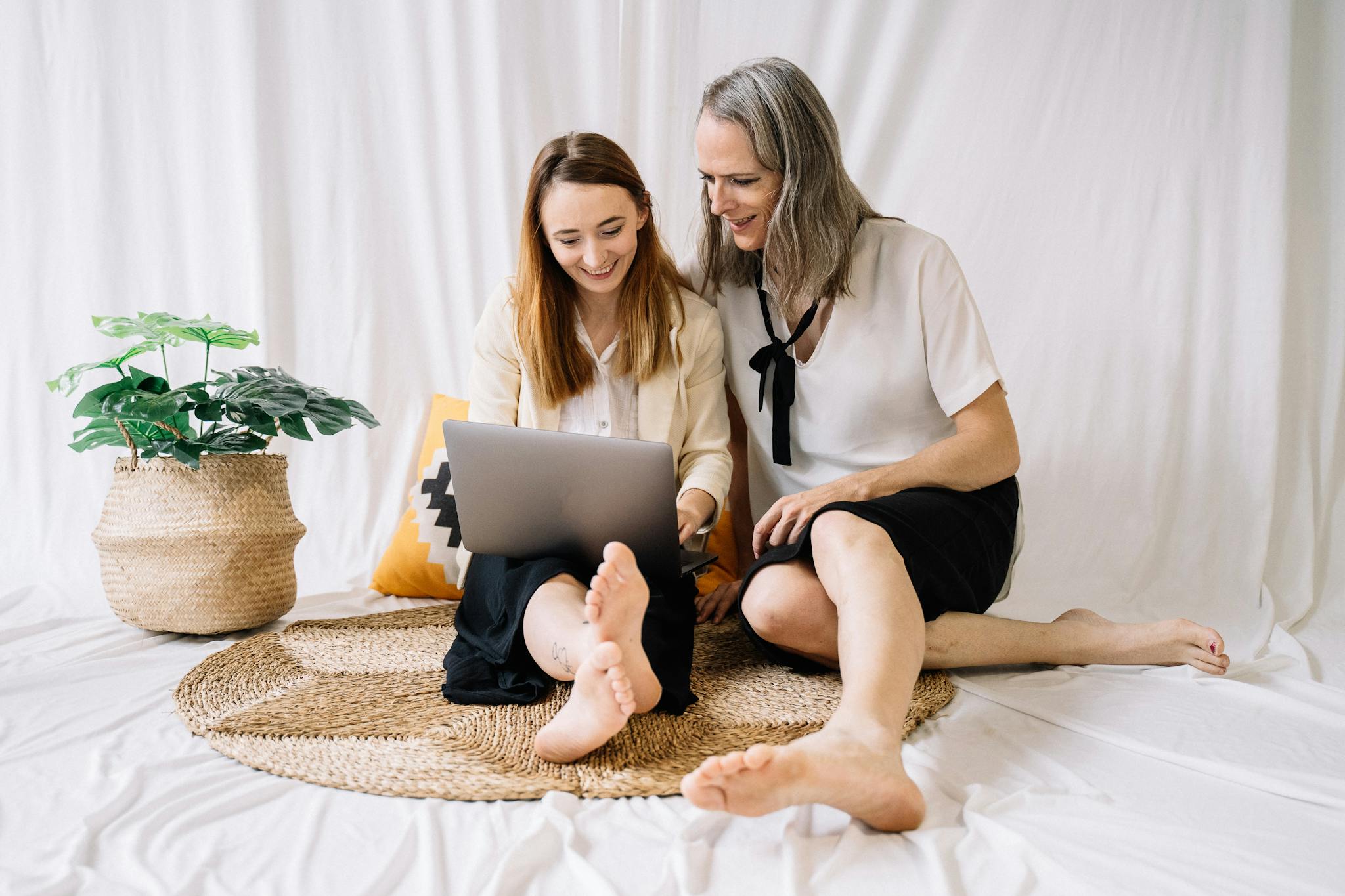 LGBTQ couple happily working together on a laptop at home, embracing remote work lifestyle.